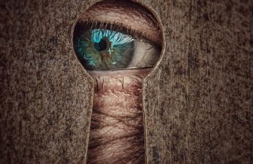 Eye looking through keyhole